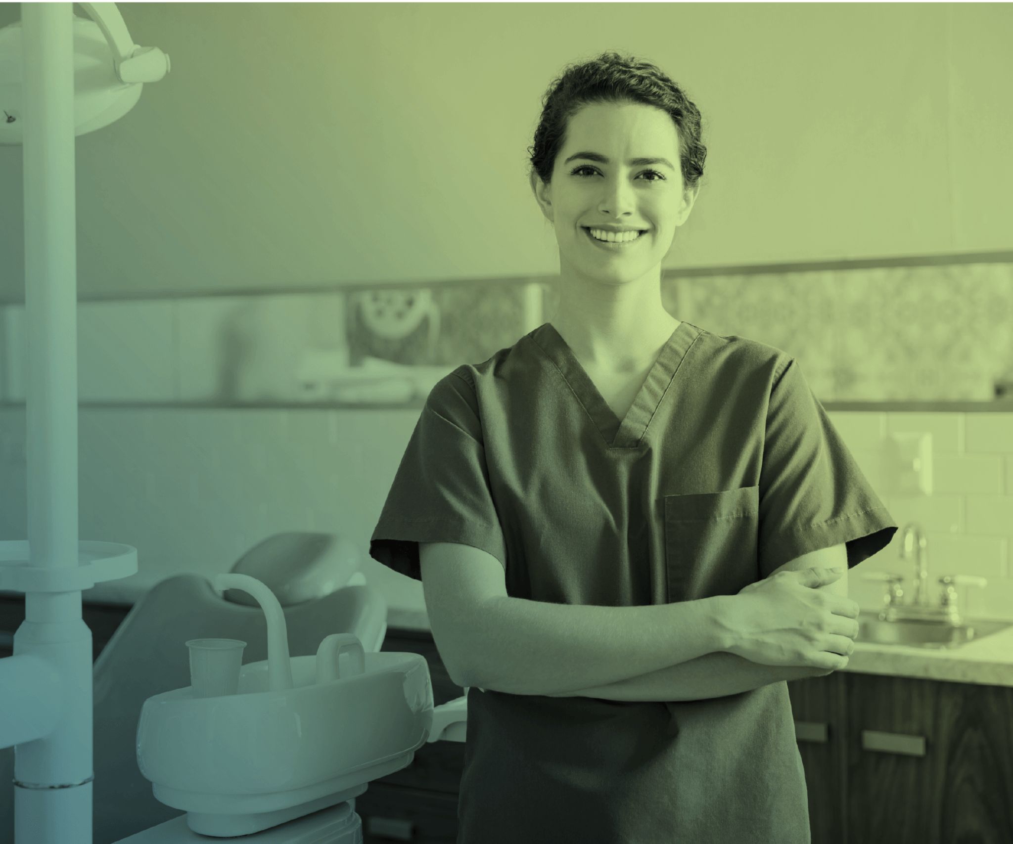A dental assistant in scrubs in a clinical setting.